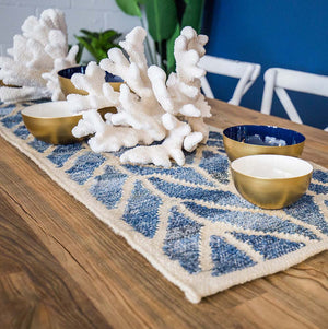  Coastal style upcycled denim blue and sustainable jute table runner in herringbone pattern on a styled dining table.