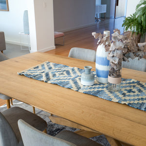 Coastal style upcycled denim blue and sustainable jute table runner in Aztec pattern on a timber table in a dining room.