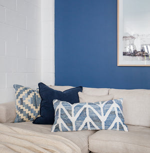 Coastal style upcycled denim blue and white cotton rectangle cushion in herringbone pattern in lounge room setting.