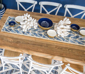  Coastal style upcycled denim blue and sustainable jute table runner in herringbone pattern styled on a timber table in a blue and white dining room.