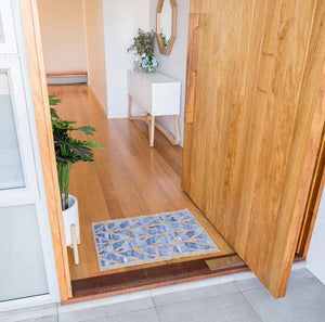 Coastal style upcycled denim blue and sustainable dark jute door mat in Herringbone pattern in entry way front door.