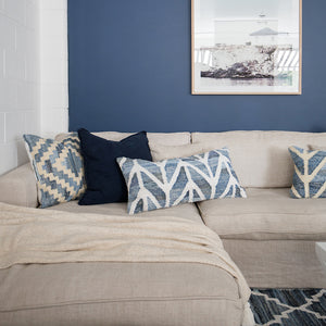 Coastal style upcycled denim blue and white cotton rectangle cushion in herringbone pattern styled on a cream couch.